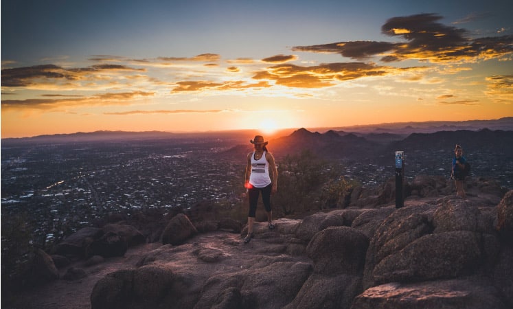 Two women take a sunset hike at Camelback Mountain in Phoenix, AZ.