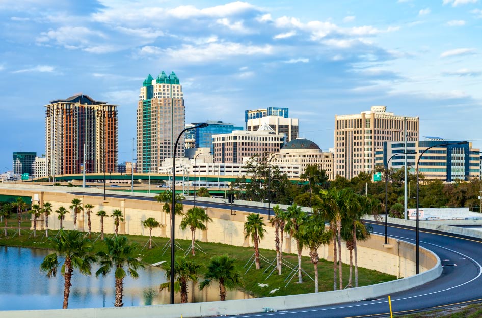 Aerial view of the Orlando, Florida, skyline with a freeway and pond in the foreground