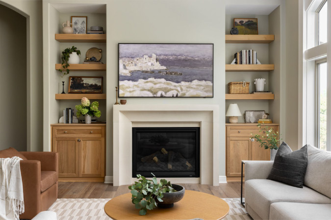 This warm, neutral-toned fireplace with built-in shelving is an excellent reference for those looking for home remodeling ideas for fireplaces with storage.