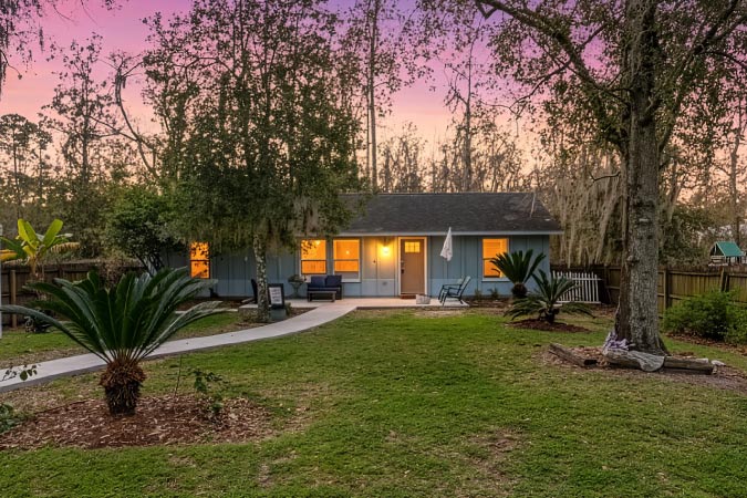 A cute one-story home in Jacksonville’s Mandarin neighborhood, featuring a very Florida front yard with stout palm trees and oak trees with dripping Spanish moss.
