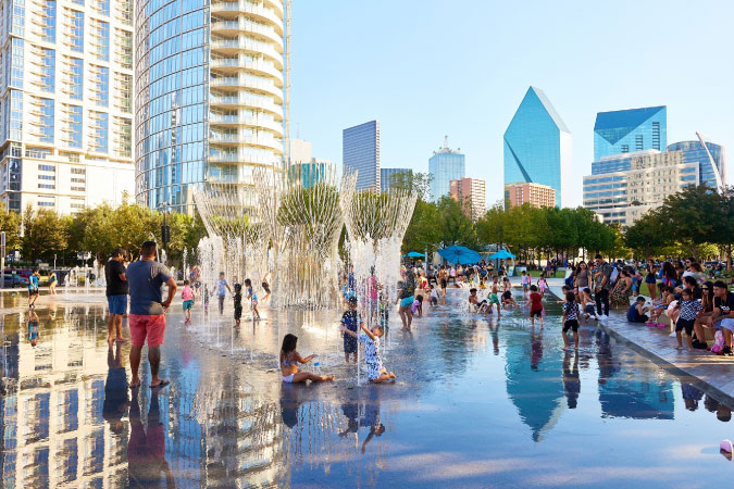 Locals to Dallas and surrounding cities like Princeton, TX, enjoy a summer day playing in the water feature at Klyde Warren Park.