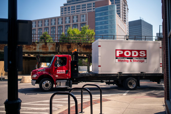 A PODS truck transports a PODS portable moving container into the big city of Chicago as part of its City Service.