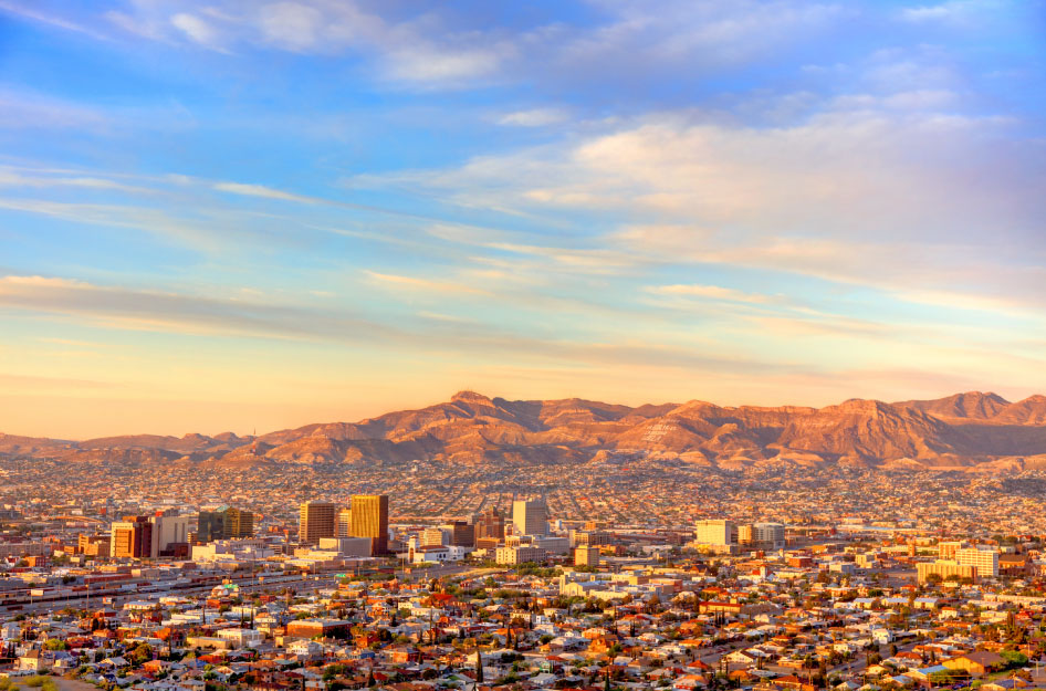 Aerial view of the city of El Paso, Texas, and surrounding mountains during sunrise.