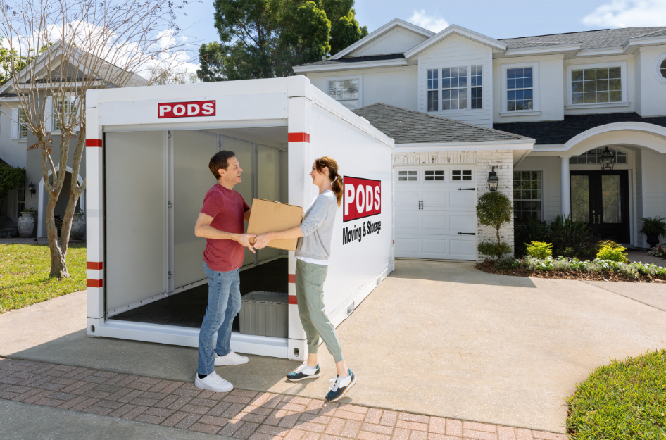 A young couple loads their PODS portable moving container to keep their moving anxiety at bay after booking their container early.