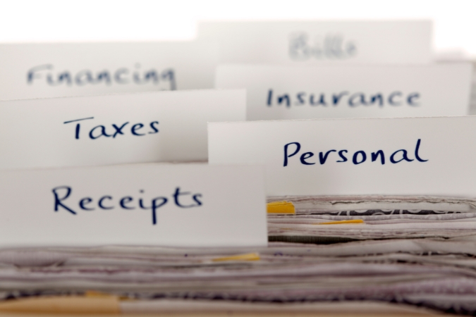 File folder labels for receipts, taxes, bills, insurance, financing, and personal documents are used to organize records related to a moving expenses tax deduction.