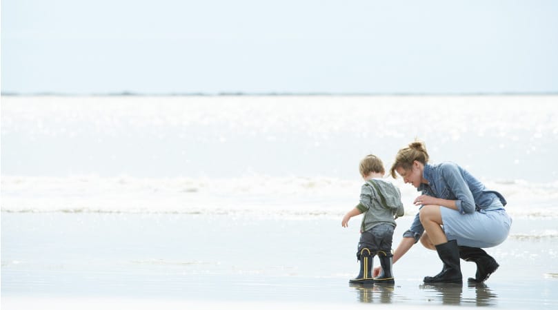 A mother and son playing in the low tide the 