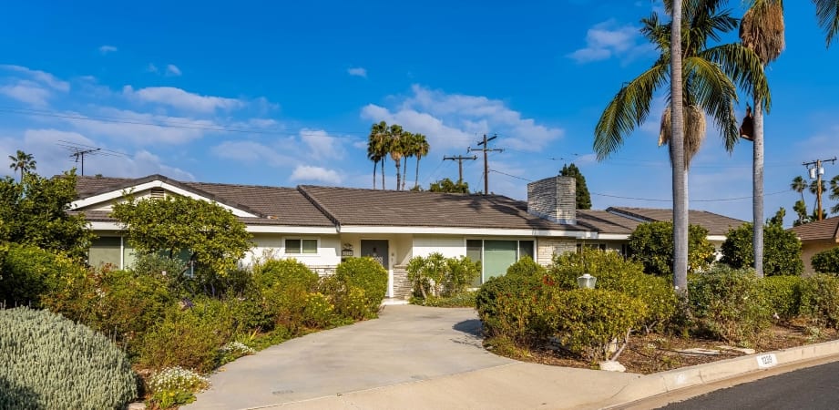A well-landscaped, mid-century modern, ranch-style home with a semi-circle driveway in the Westmont neighborhood of Anaheim, CA
