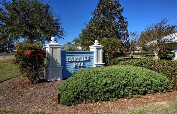 A blue sign in front of the Caroline village pool, reading “Caroline Pool.”