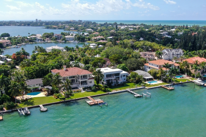 An aerial view of waterfront homes along Bay Island in Sarasota, Florida, one of the most popular cities to move to in 2026, with tropical foliage and bay waters in the background.