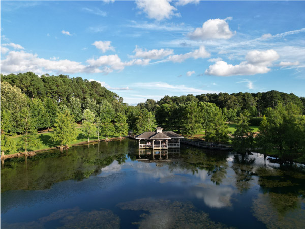 A wooden gazebo jutting out into a lake in a forested part of Florence — a city in The Shoals region of Alabama.