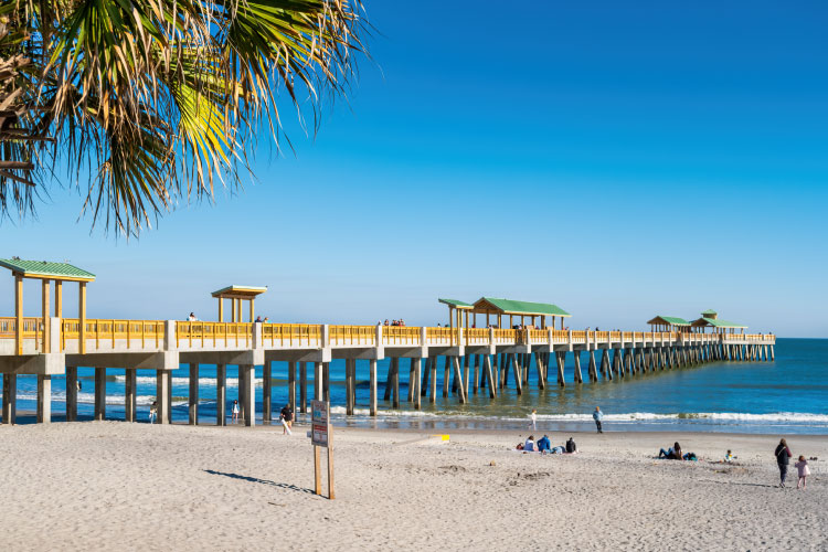 Half a dozen people enjoy a peaceful day beside the Folly Beach Pier near Charleston, South Carolina.