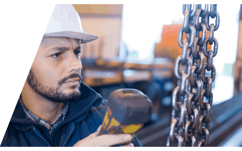 technician using handheld remote on a chain hoist