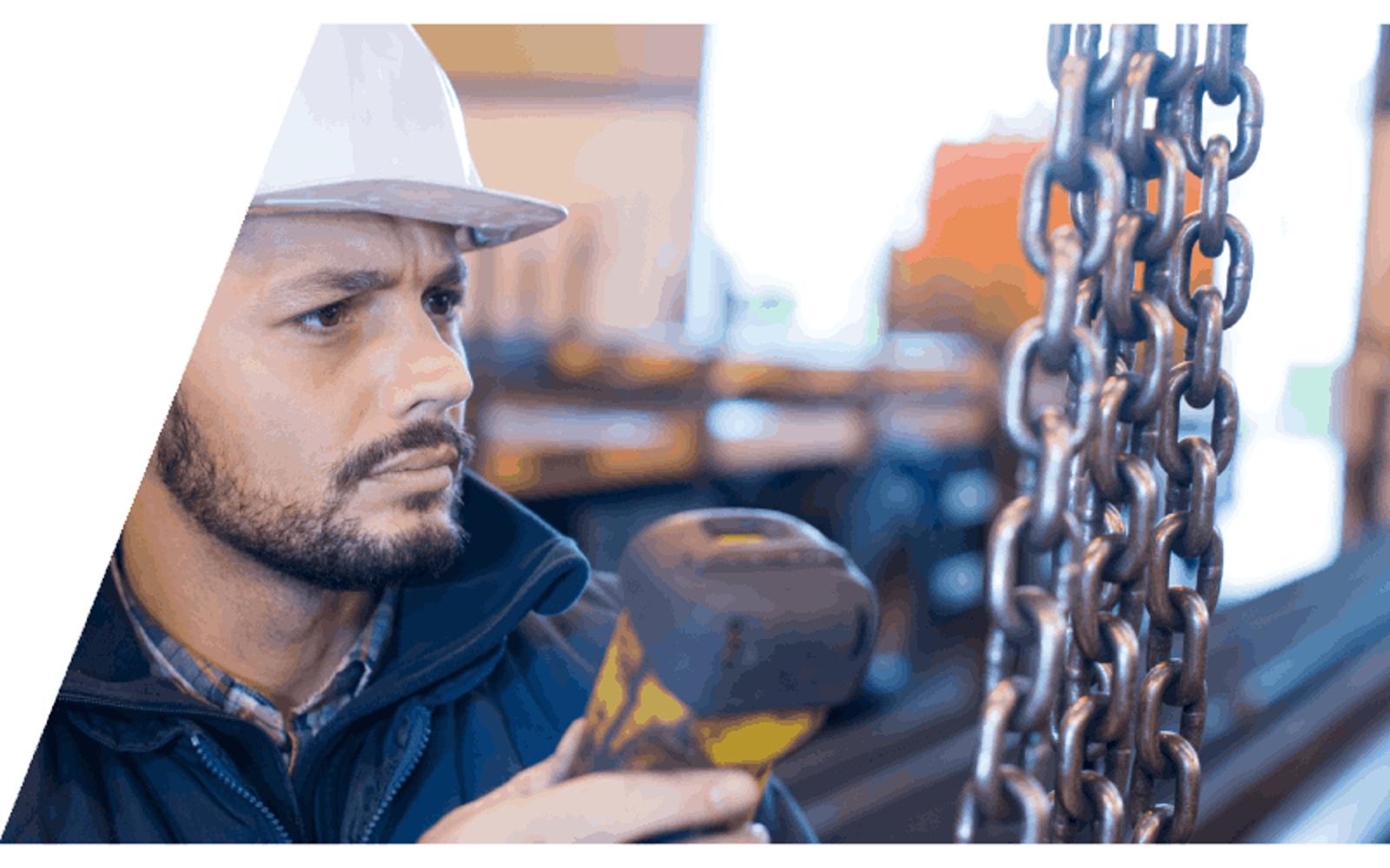 technician using handheld remote on a chain hoist
