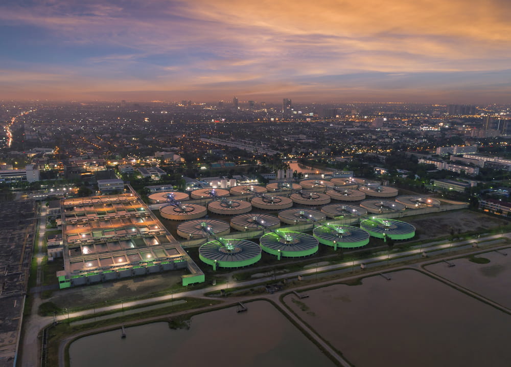 Aerial view water treatment plant at dusk with cityscape for Municipal water supply