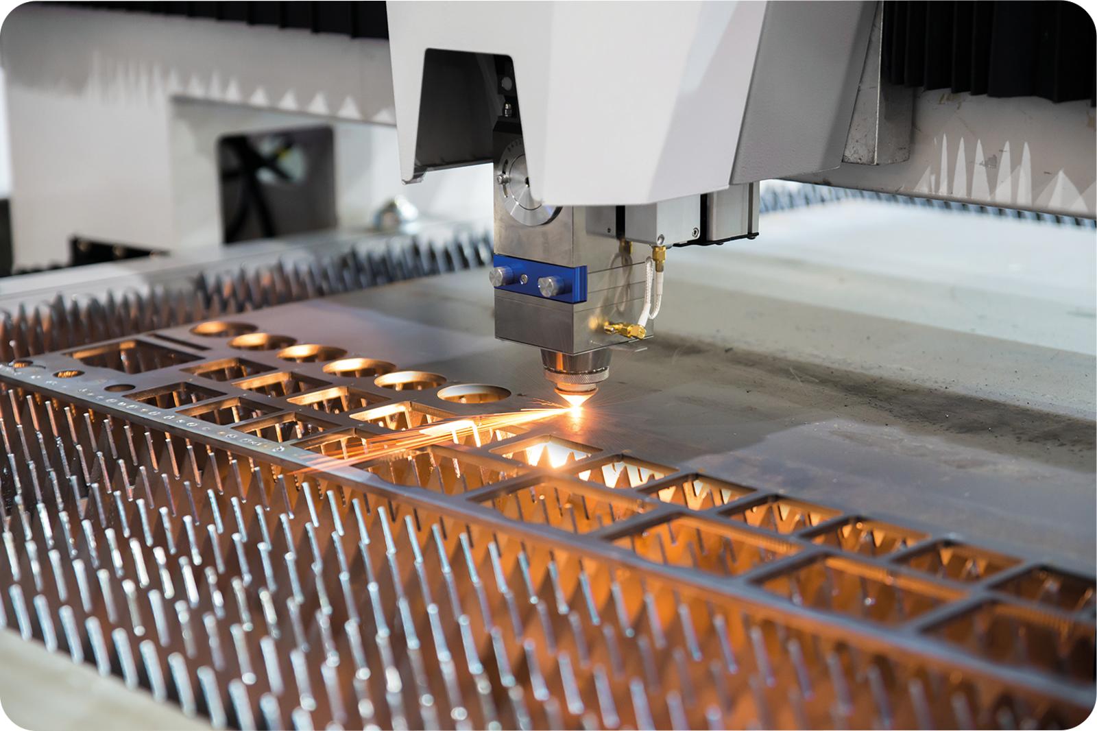 Industrial laser cutting production line with stacked metal sheets and finished components prepared for manufacturing.