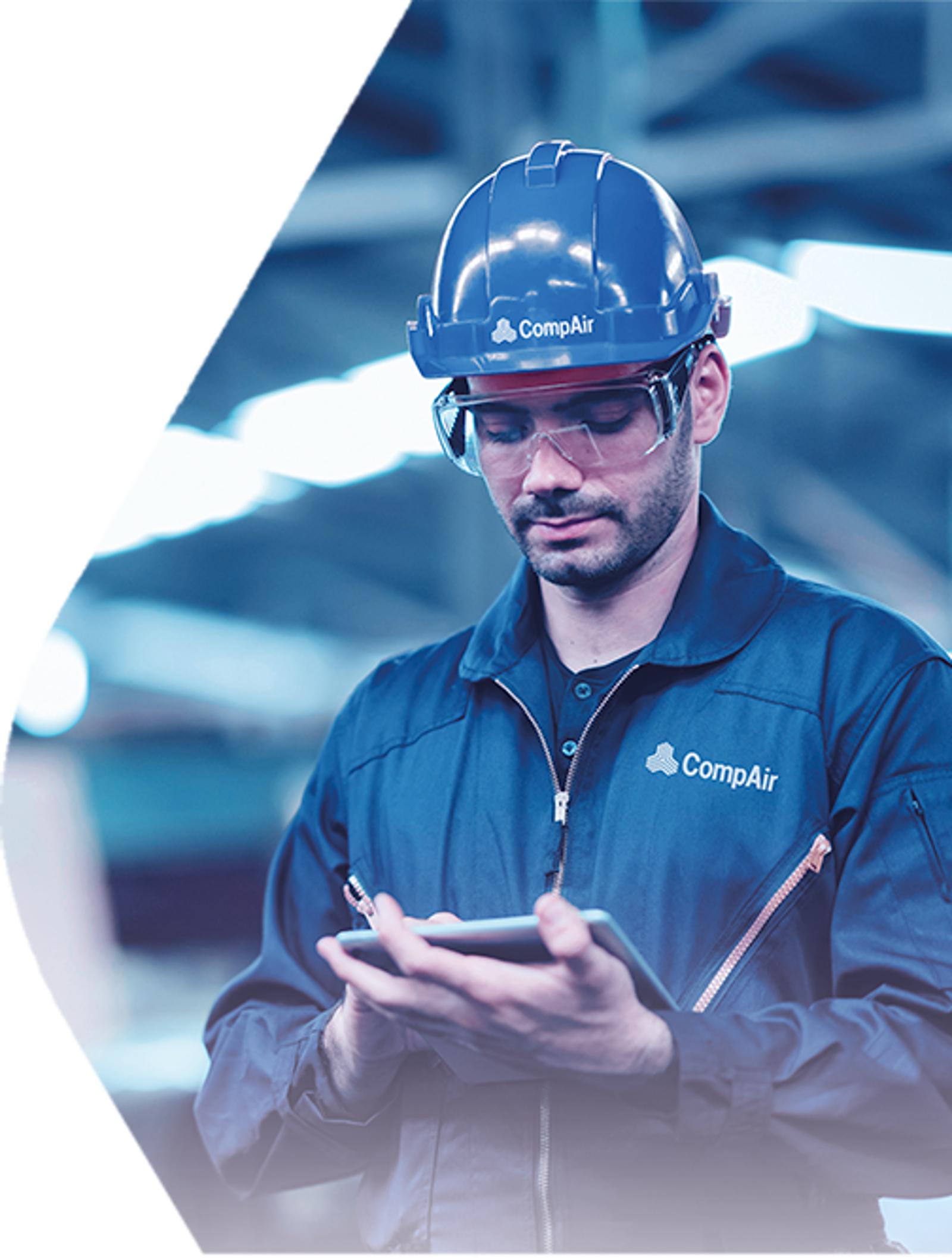 Industrial technician using tablet for compressor monitoring