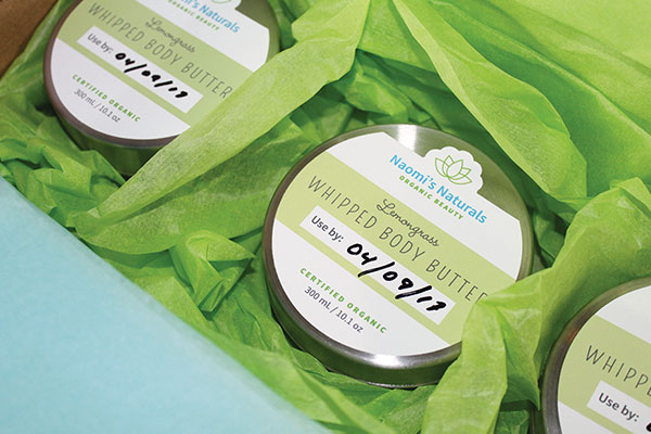 Woman writing an expiration date on a cosmetic packaging label