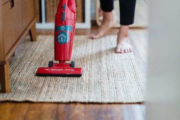 Person vacuuming an area rug.