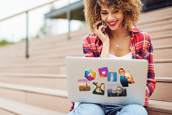 Millennial woman working on a laptop covered in stickers
