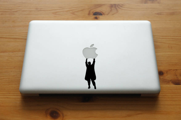 Sticker of a person holding onto an apple on MacBook.