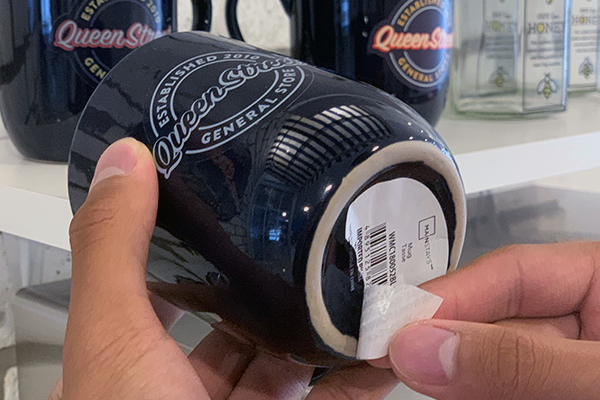 Removing the sticker from the bottom of the mug.