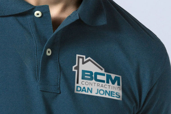 Man holding a die-cut single sticker of a company logo