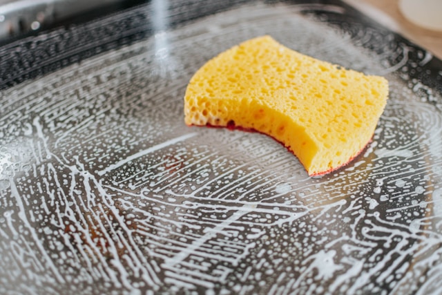 A sponge being used for cleaning dishes
