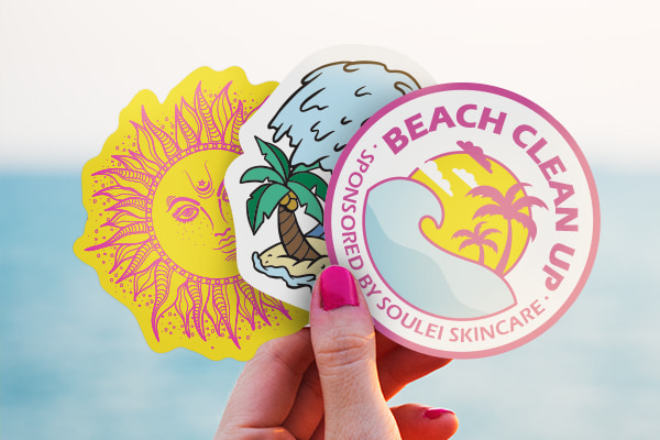 Eco-Safe stickers fanned out in a hand.