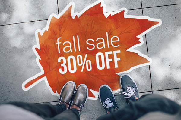 Custom street decal on a sidewalk pointing to a business event