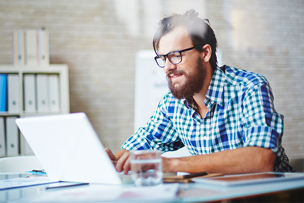 man at an office working on laptop 