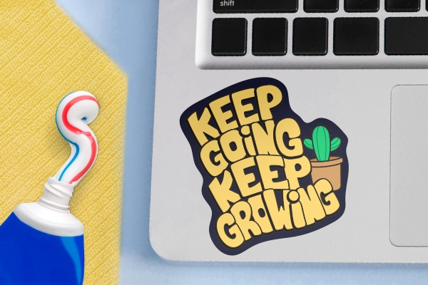 A sticker placed right beside the mouse pad of a Macbook.