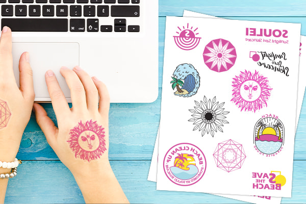 A variety of stickers beside a laptop.