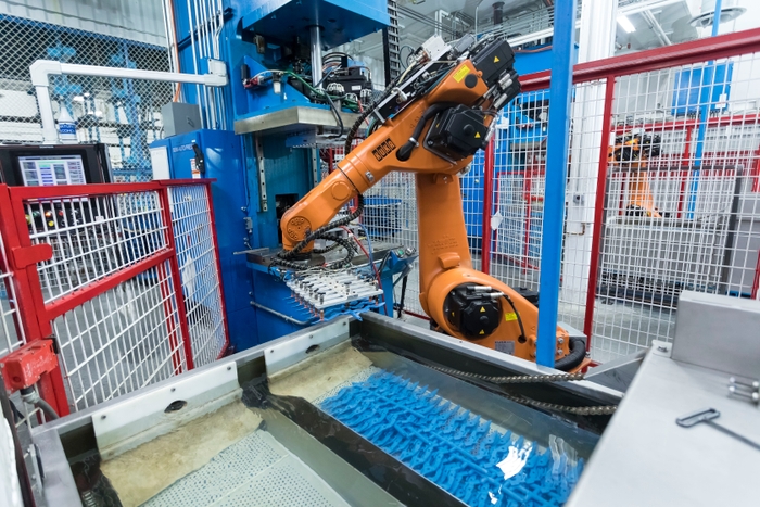 Automated machine dropping molded parts into a kiln