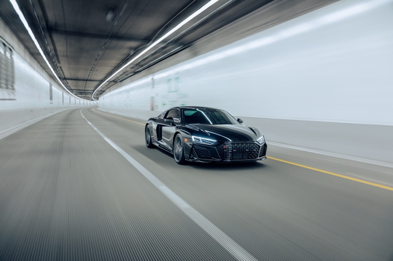 Black sports car driving in a tunnel