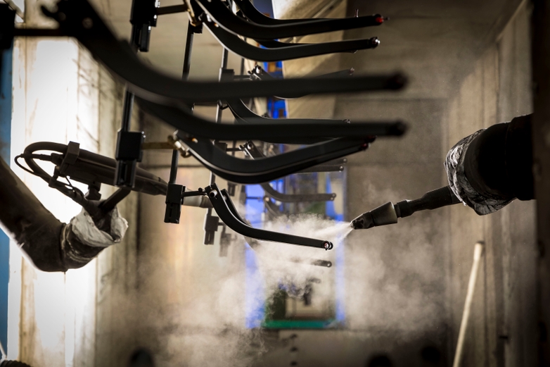 Investment casted parts being sprayed with a surface finish