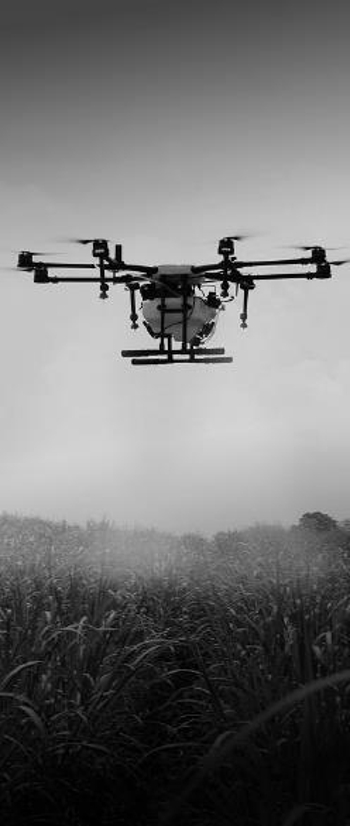 Agricultural drone spraying field with pesticides.