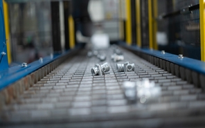 Automated conveyor belt transporting die cast parts