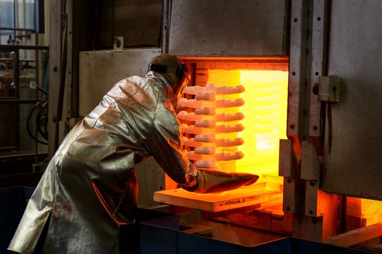 Signicast employee inserting the investment castings into the fire