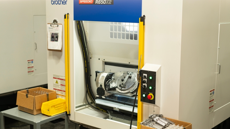 Dynacast CNC machine with final CNC parts in a box