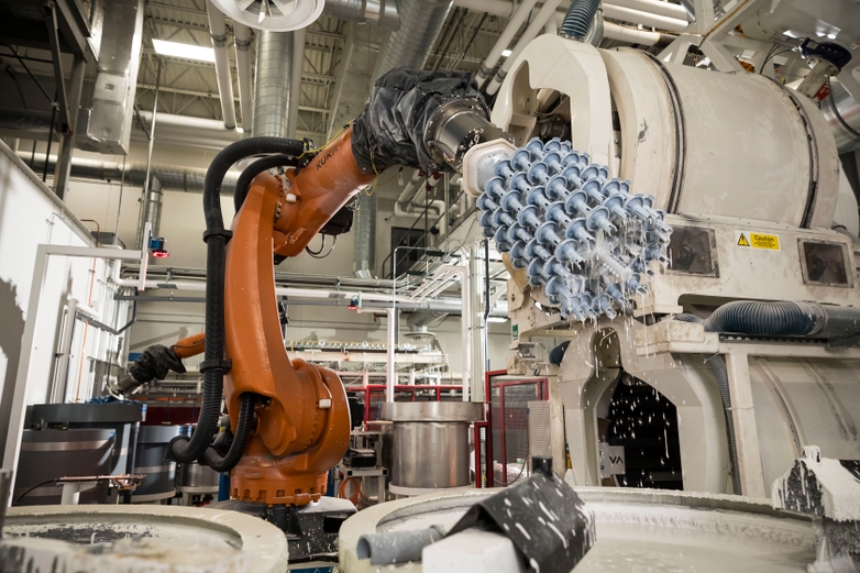 Investment casting machine dipping mold into slurry