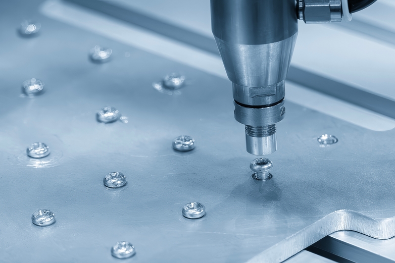Sheet of metal with screws being drilled in