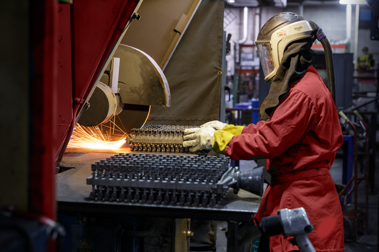 Employee cutting a part with a blade