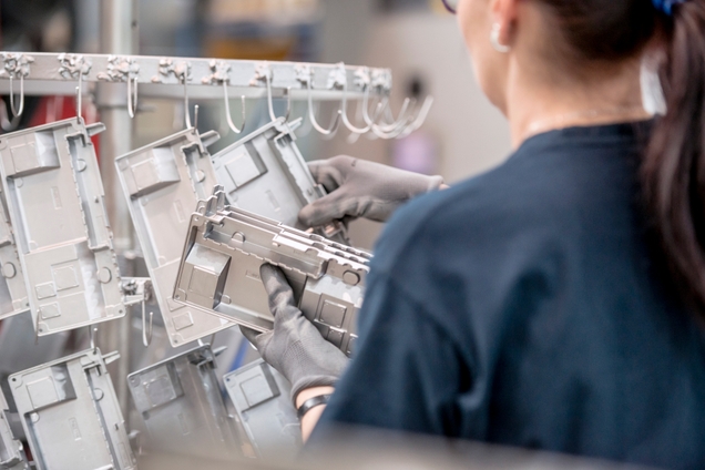 Employee hanging parts for the surface finish to dry