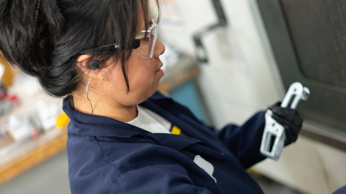 A woman performing a die casting sub assembly