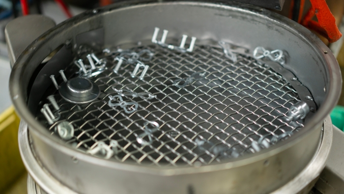 Final metal manufactured parts shaking in a container