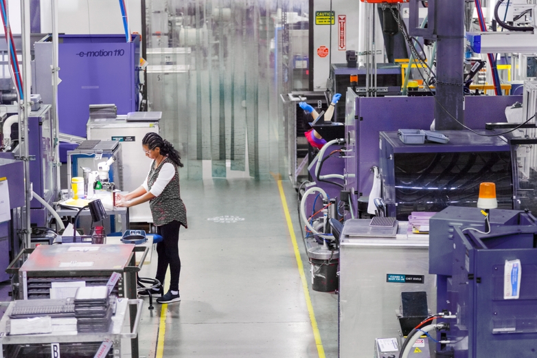 OptiMIM employee working beside MIM machines