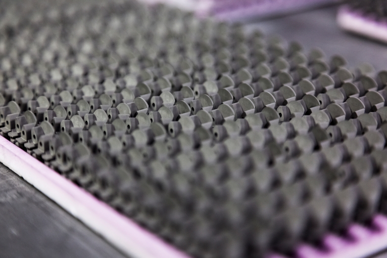 Metal injection molding parts organized in rows