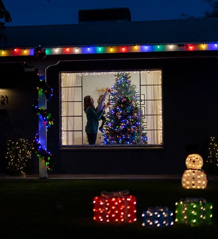family decorating a tree inside